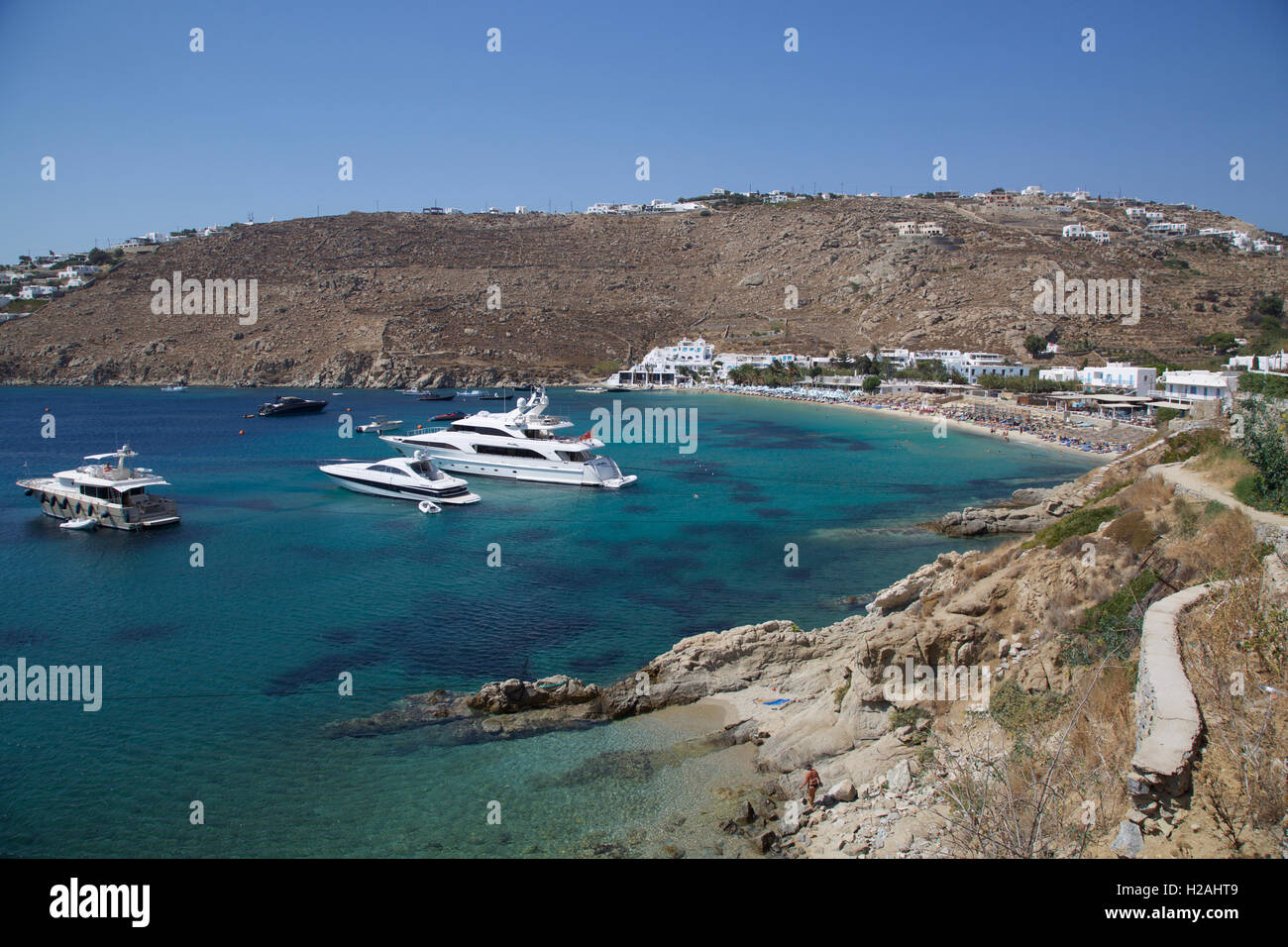 Psarou Beach Bay Insel Mykonos Griechenland mit blauem Himmel Meer und Yachten von Klippe mit Yachten Stockfoto