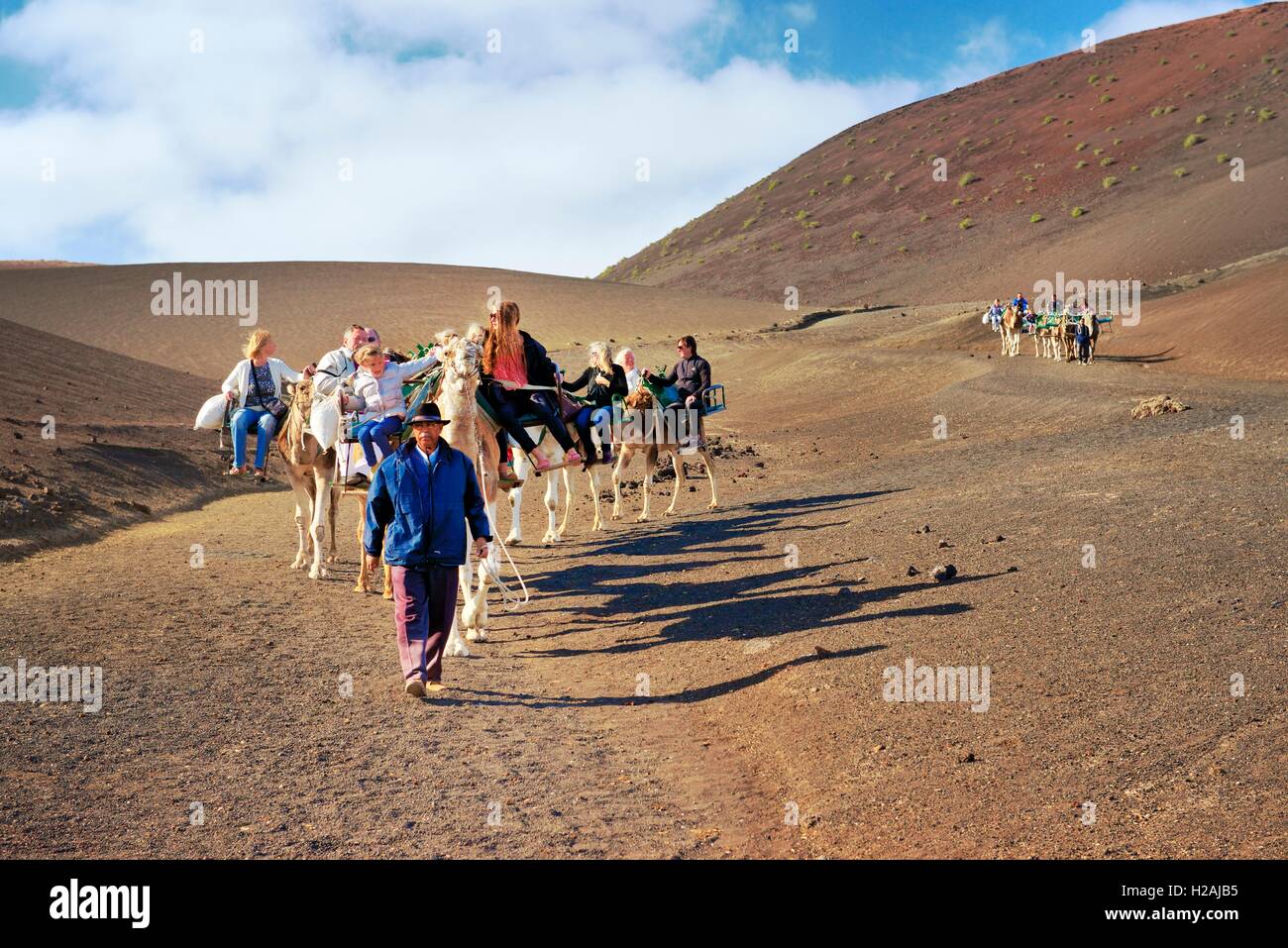 Touristischen Kamel reitet Echadero de Los Camellos durch vulkanische Landschaft. Nationalpark Timanfaya, Lanzarote, Kanarische Inseln Stockfoto