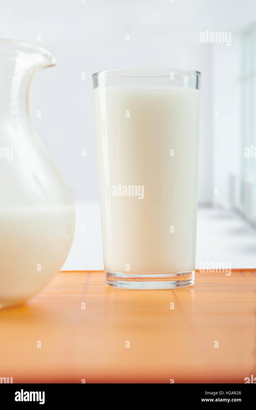 Glas Milch und Krug auf Tisch Stockfoto