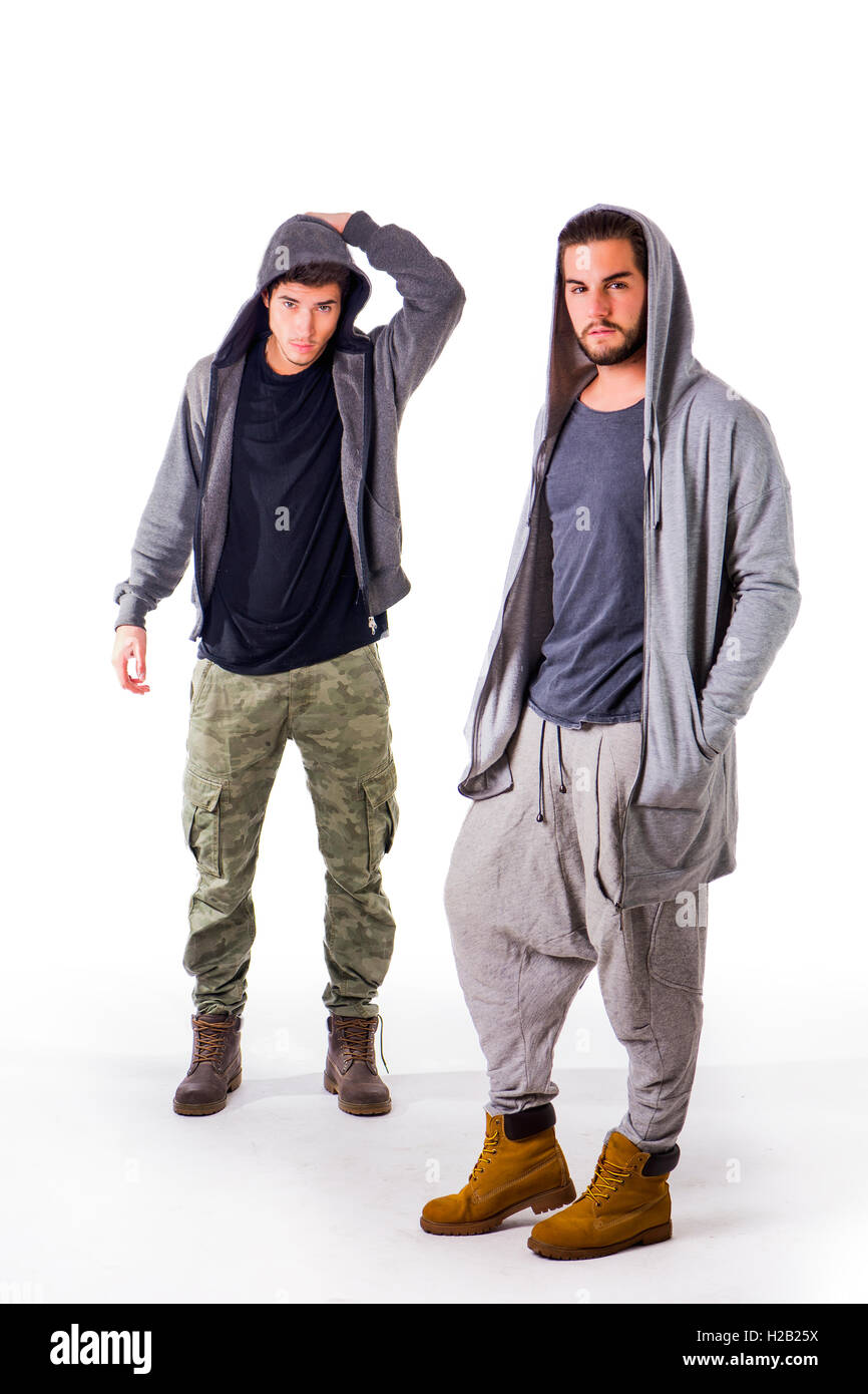Zwei junge Männer, die militärische und sportliche Kleidung zu tragen. Hauben am Kopf zu tragen. Studio gedreht. Stockfoto