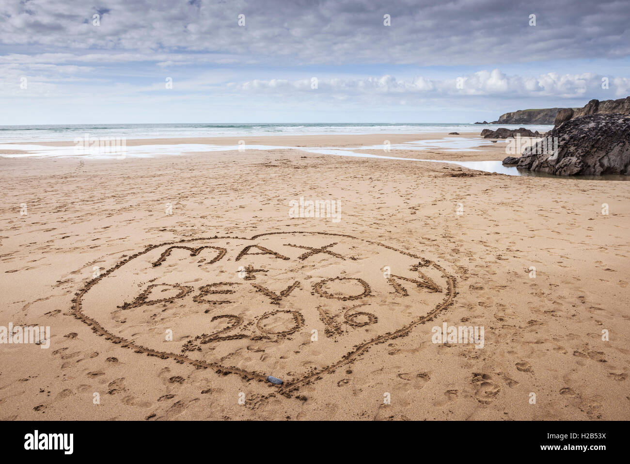 Namen in den Sand geschrieben am Strand von Bedruthan Steps in Cornwall. Stockfoto