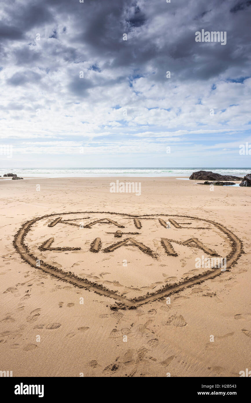 Namen und ein Herz in den Sand am Strand von Bedruthan Steps in Cornwall gezeichnet. Stockfoto
