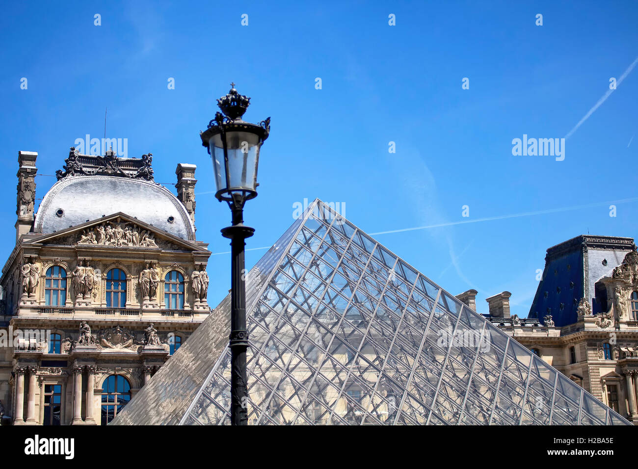 Straßenlaterne vor berühmten Glaspyramide im Innenhof des Louvre in Paris. Stockfoto