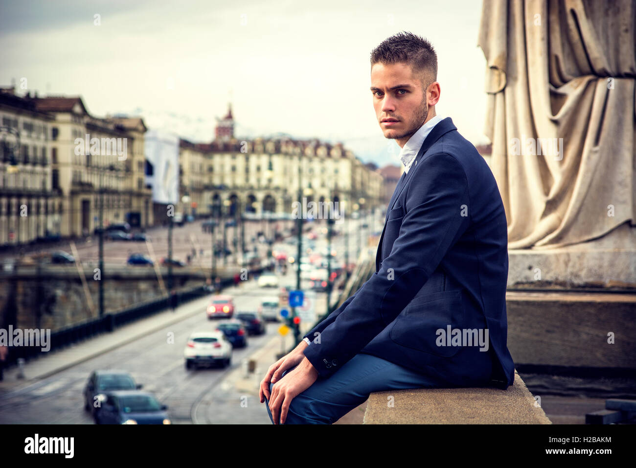 Hübscher junger Mann im Freien tragen Jacke und Hemd stehen historische Gebäude in europäischen Stadt. Turin, Italien Stockfoto