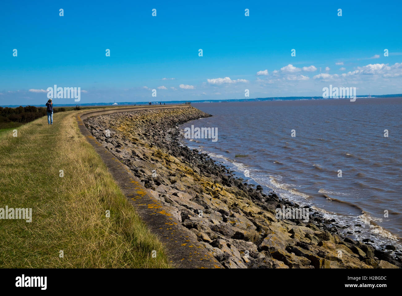 Walker am Küstenweg und Deich, Goldcliff in der Nähe von Newport, Monmouthshire, Wales, UK, Severn Mündung Stockfoto