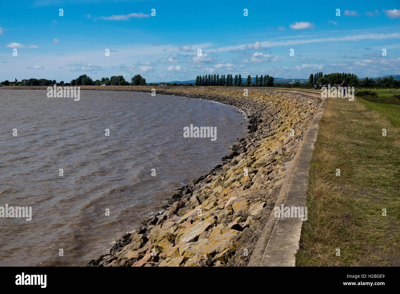 Walker am Küstenweg und Deich, Goldcliff in der Nähe von Newport, Monmouthshire, Wales, UK, Severn Mündung Stockfoto