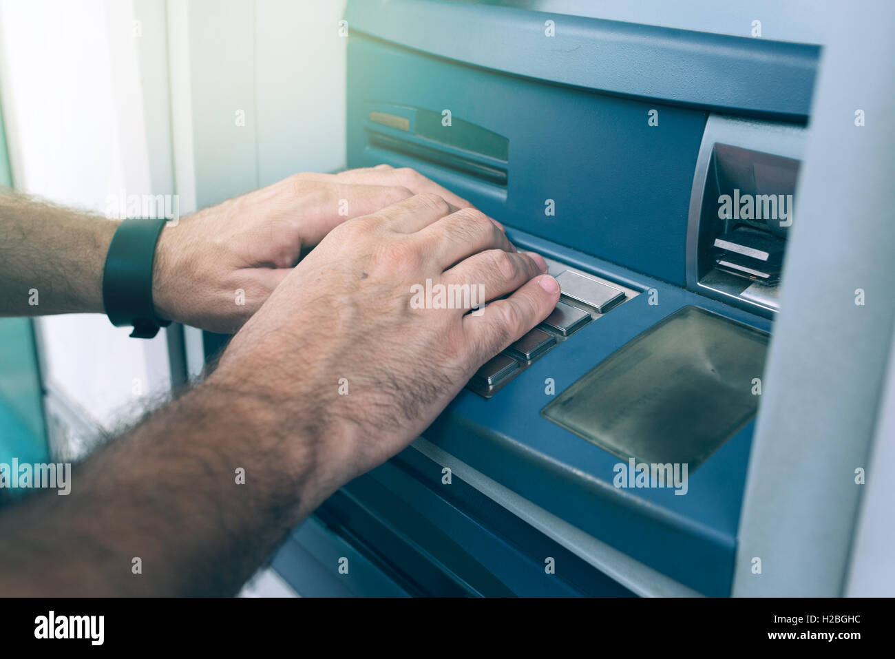 Eingabe von PIN an Geldautomaten für Bargeldbezug Geld Hände Stockfoto