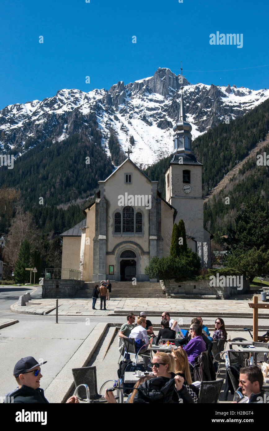 Leute sitzen in einem Café an der Kirche Saint-Michel de Chamonix, Chamonix, Frankreich Stockfoto