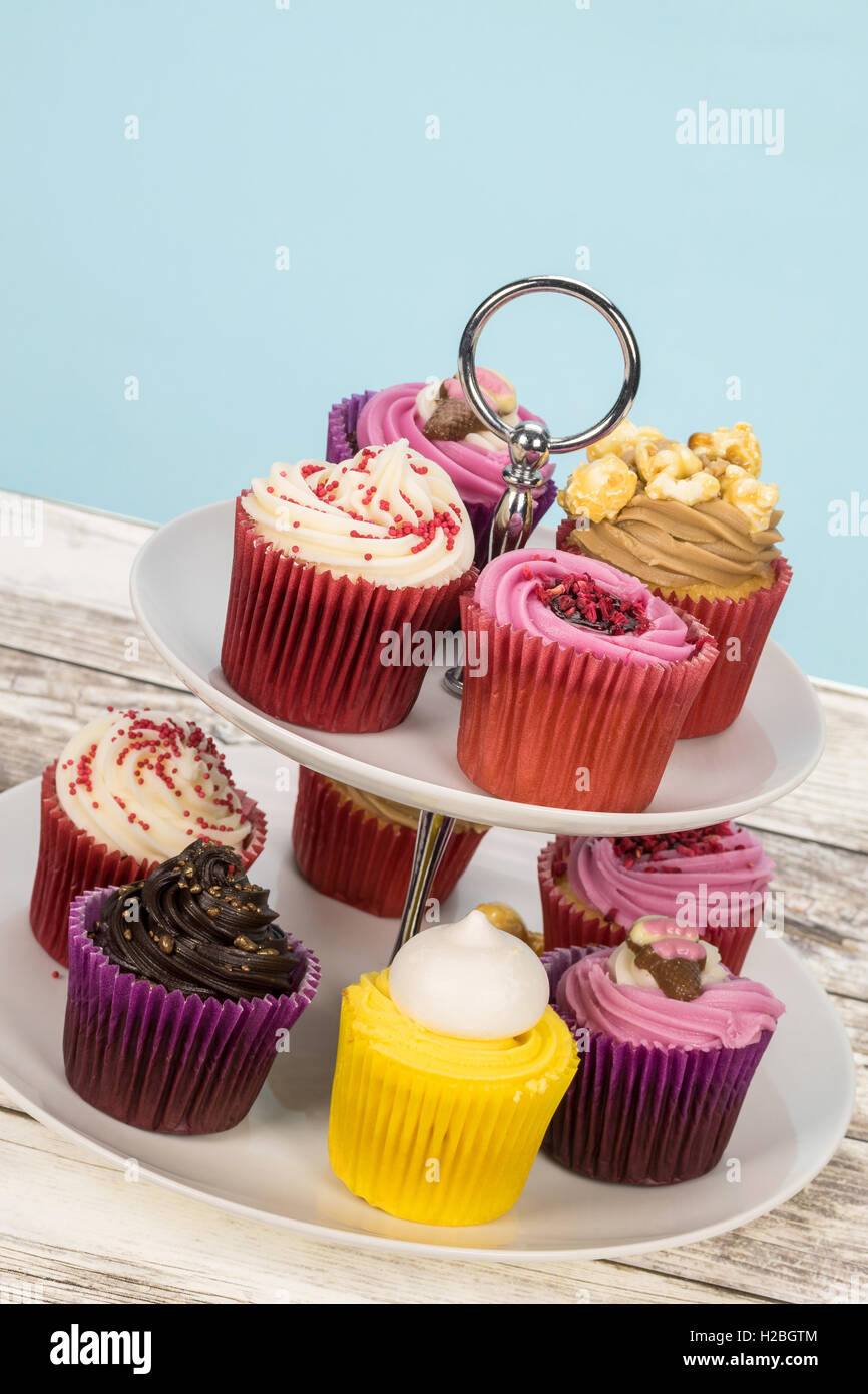 Eine Auswahl von dekorierten Cupcakes auf eine Kuchenplatte - gekippt erschossen Stockfoto