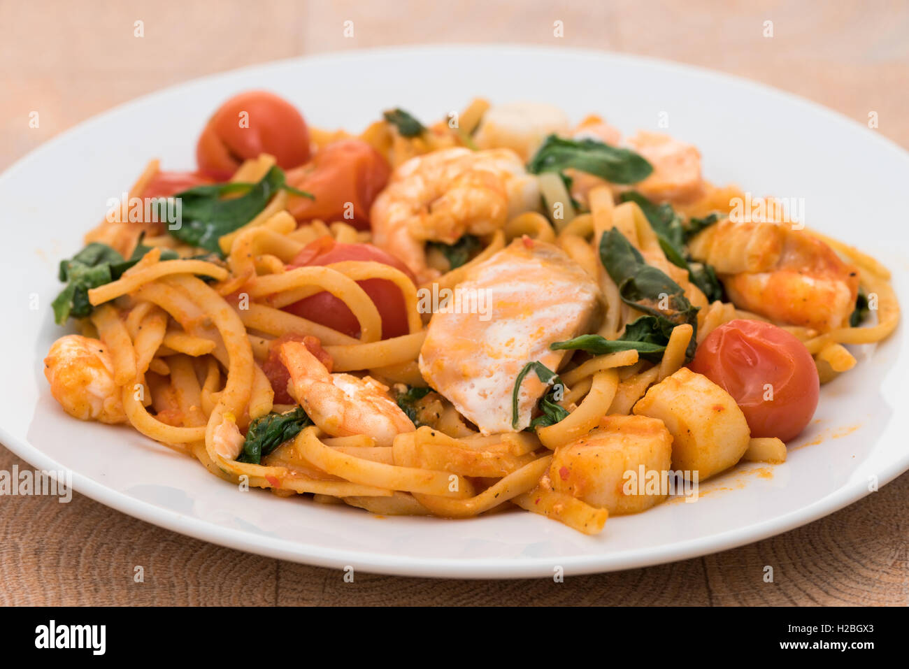 Linguine Pasta mit Meeresfrüchten mit König Garnelen, Jakobsmuscheln und Lachs Stockfoto