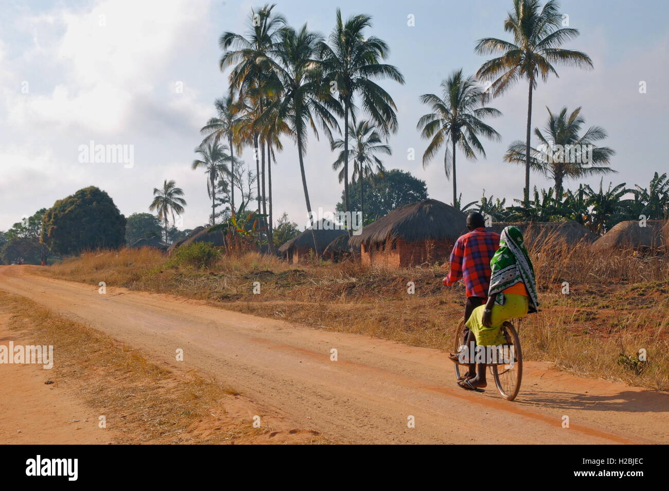 Paar fahren zusammen mit dem Fahrrad in afrikanischen Dorf Stockfoto