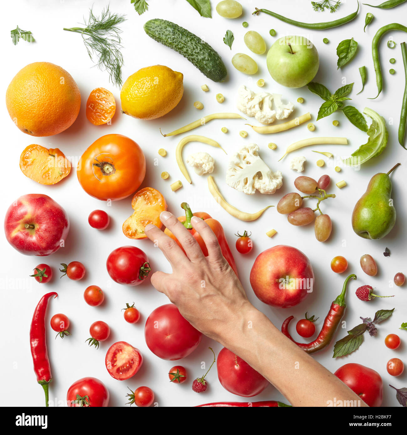 Weibes Hände putting Food auf dem weißen Hintergrund verschiedener Früchte und Gemüse auf weißem Hintergrund, Ansicht von oben. Gewichtsverlust, Stockfoto