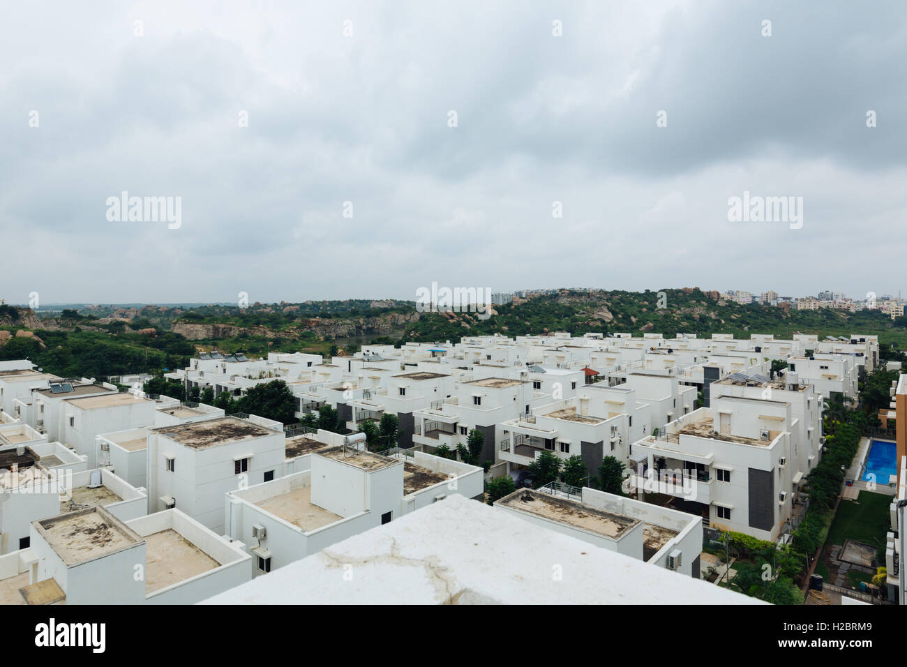 Reihenhäuser mit felsigem Gelände im Hintergrund in Hyderabad, Indien Stockfoto