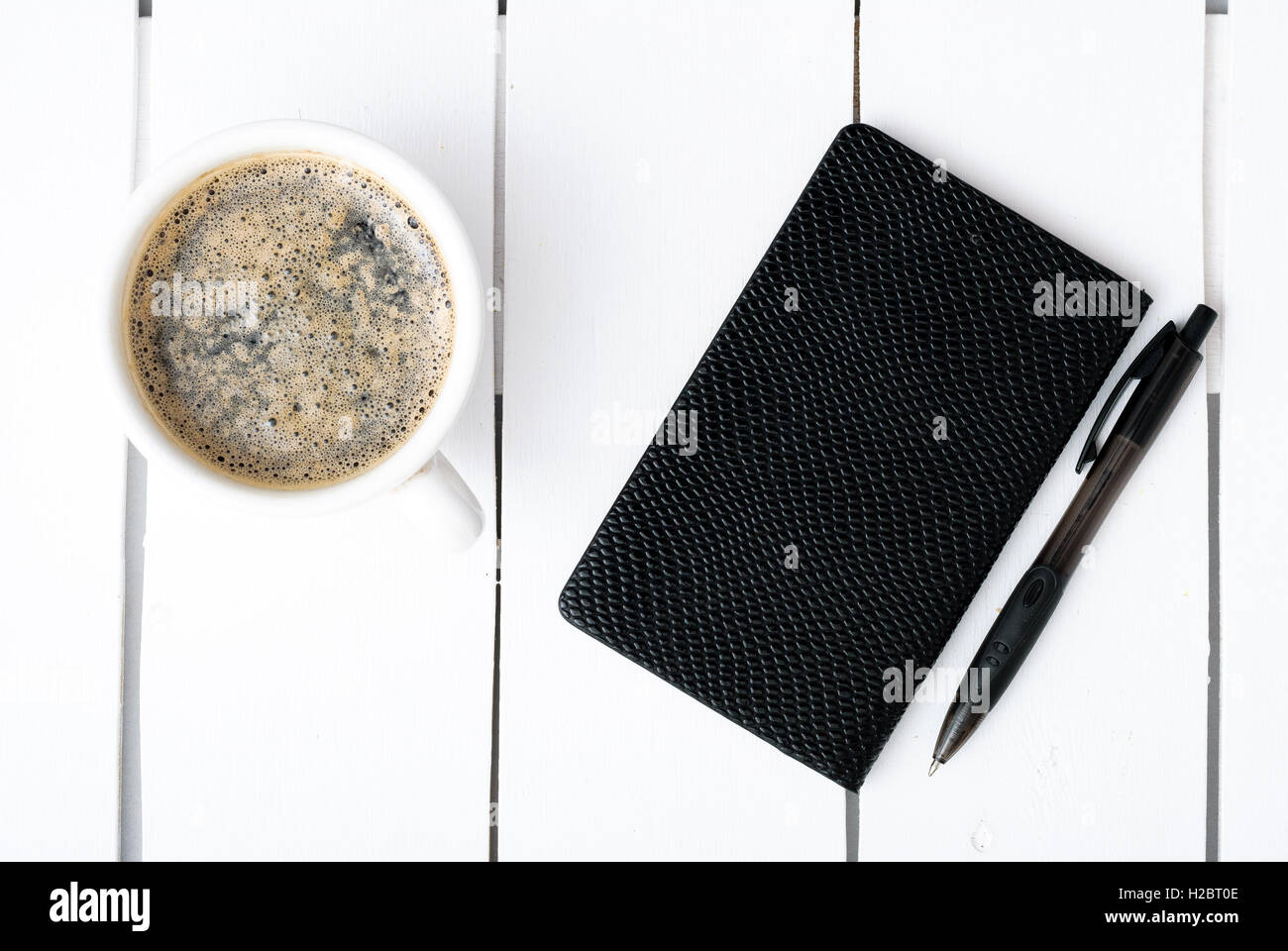 Smartphone mit Notebook und Tasse starken Kaffee Stockfoto