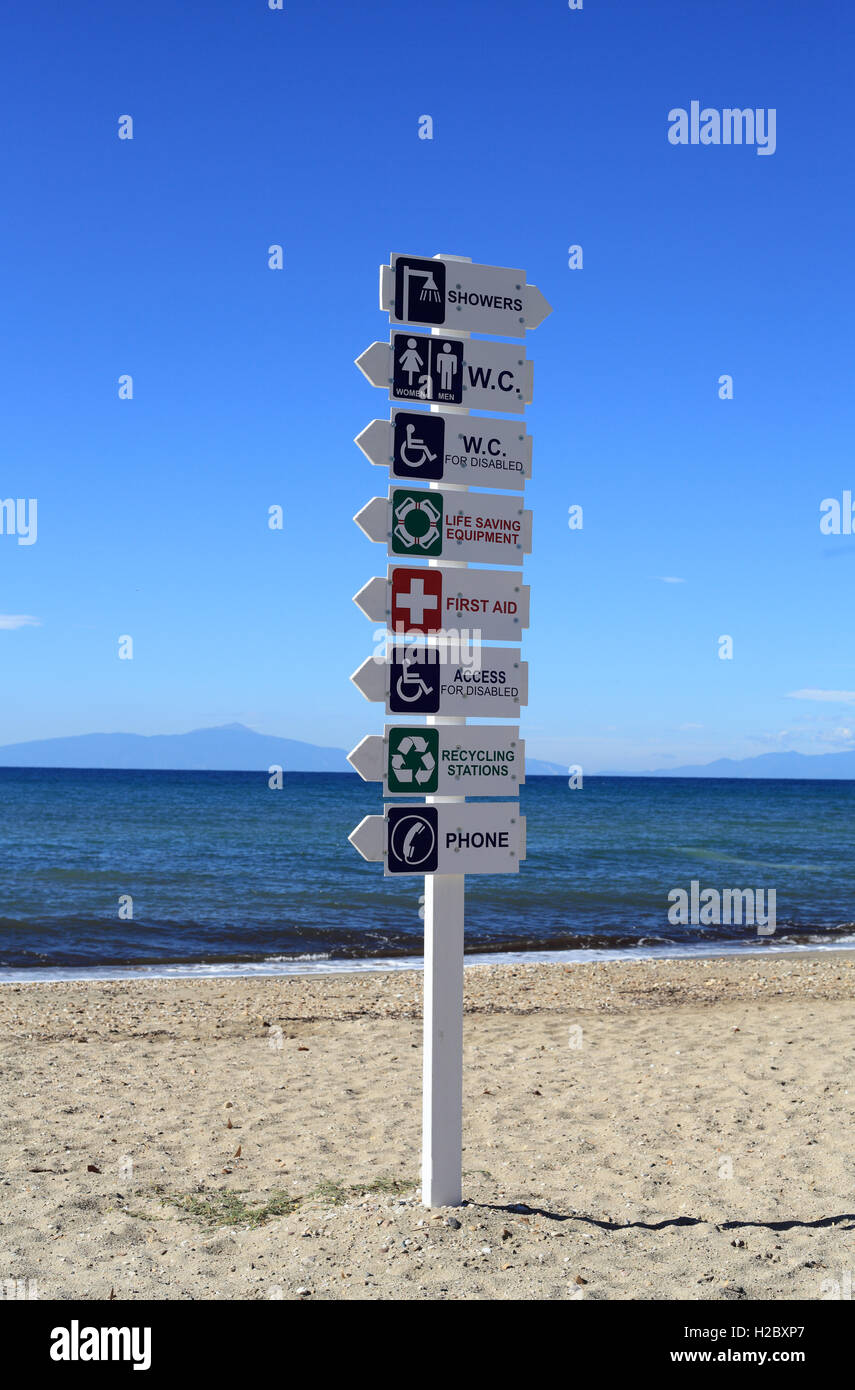 Hinweisschild für WC, erste Hilfe, Zugang für Behinderte, Telefon, recycling am Strand von Nea Moudania, Mazedonien, Griechenland Stockfoto