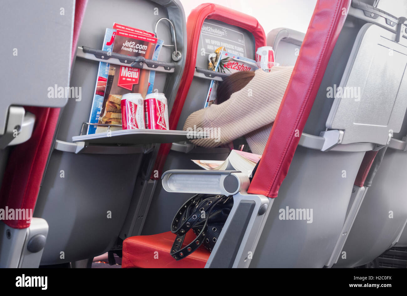 Beifahrerin schlafen auf Jet2.com Flug von Großbritannien nach Spanien mit Bierdosen auf Lebensmittel-Fach Stockfoto