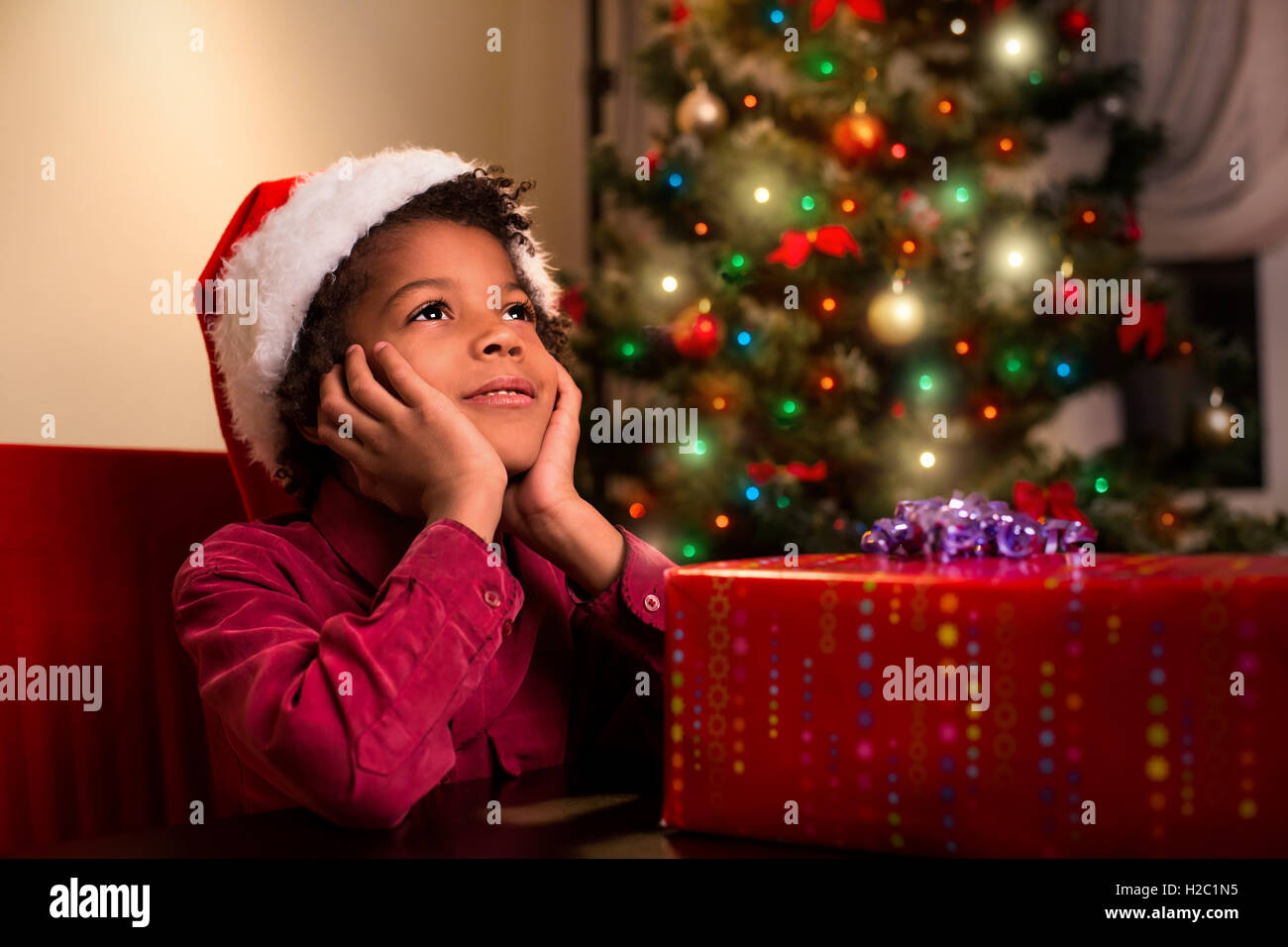 Afroamerikanischen jungen in der Nähe von Weihnachtsgeschenk. Stockfoto