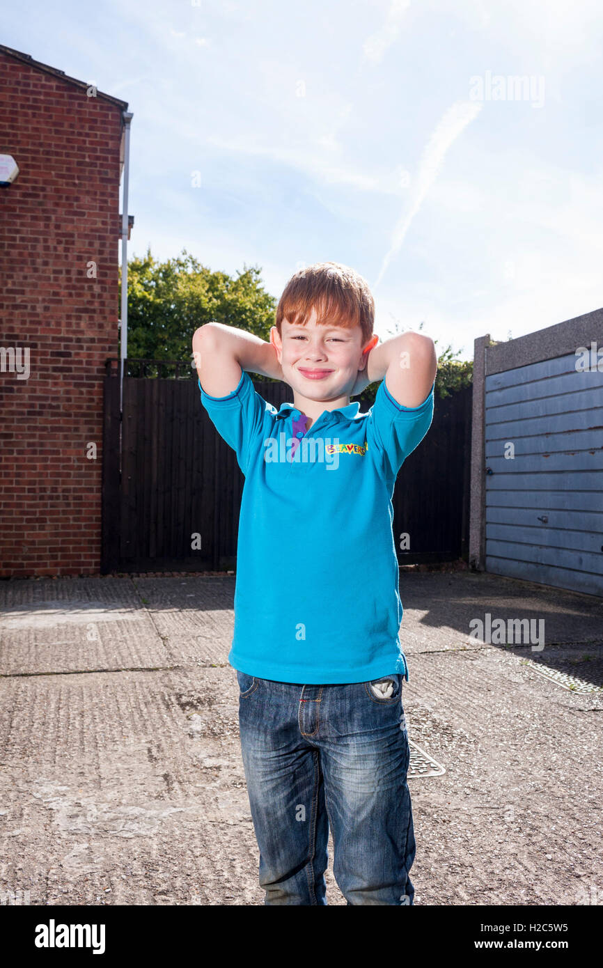 Ein kleiner Junge draußen an einem sonnigen Tag ein helles Blau Biber Scout einheitliche t-Shirt Stockfoto