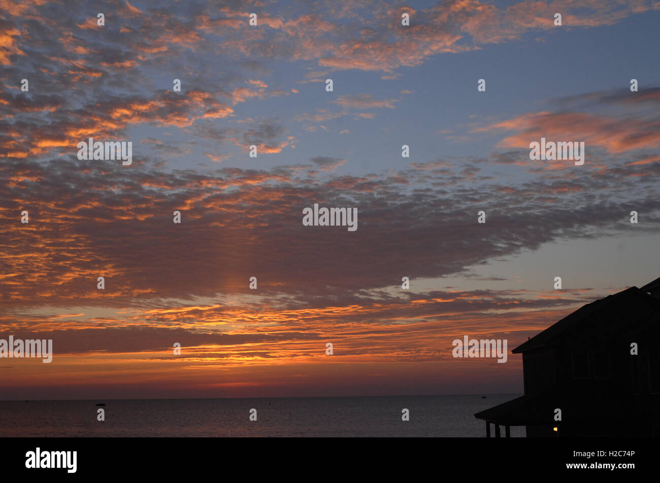 Sonnenuntergang Sonnenaufgang Himmel Urlaub Strand Haus Silhouette mit warmen Schein der Sonne Kontrast Schwarz auf Farbe Stockfoto