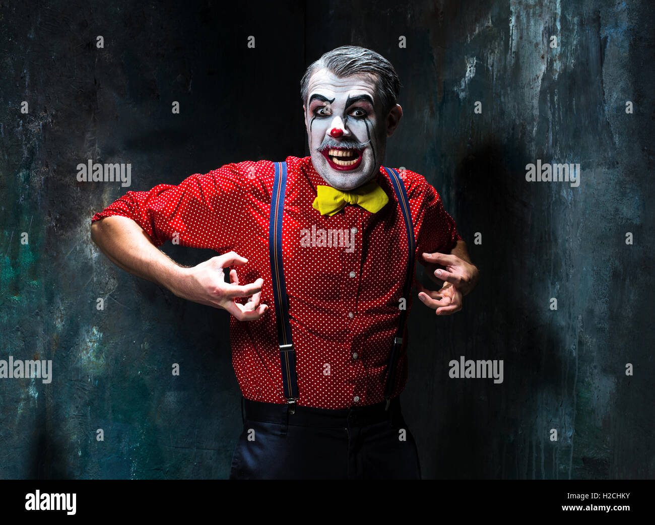Schreckliche Clown und Halloween-Thema: verrückte rote Clown in einem Hemd mit Strapsen Stockfoto