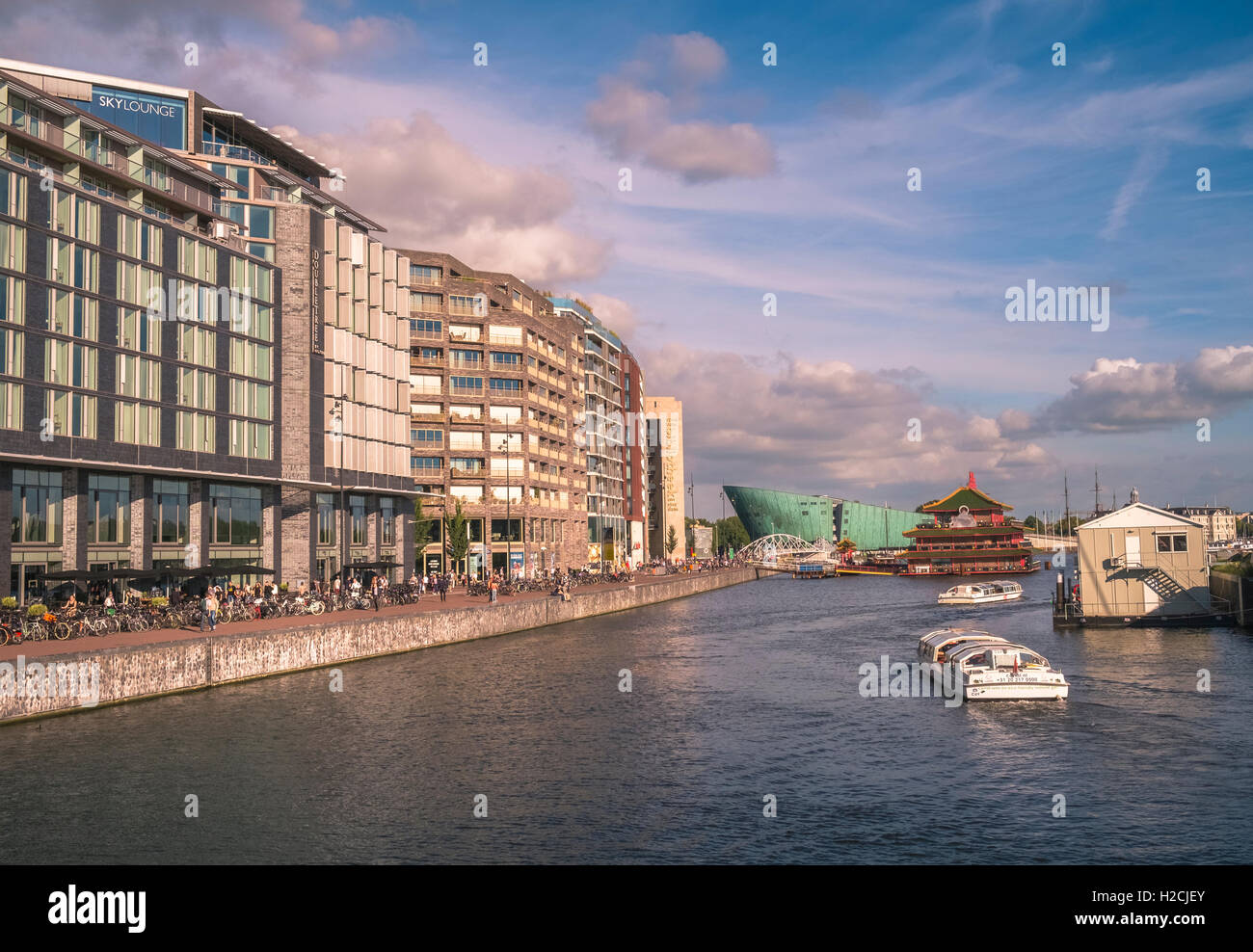 Architektur entlang Oosterdokskade, Eastern Dock Insel mit Wissenschaftsmuseum NEMO in Ferne Stockfoto