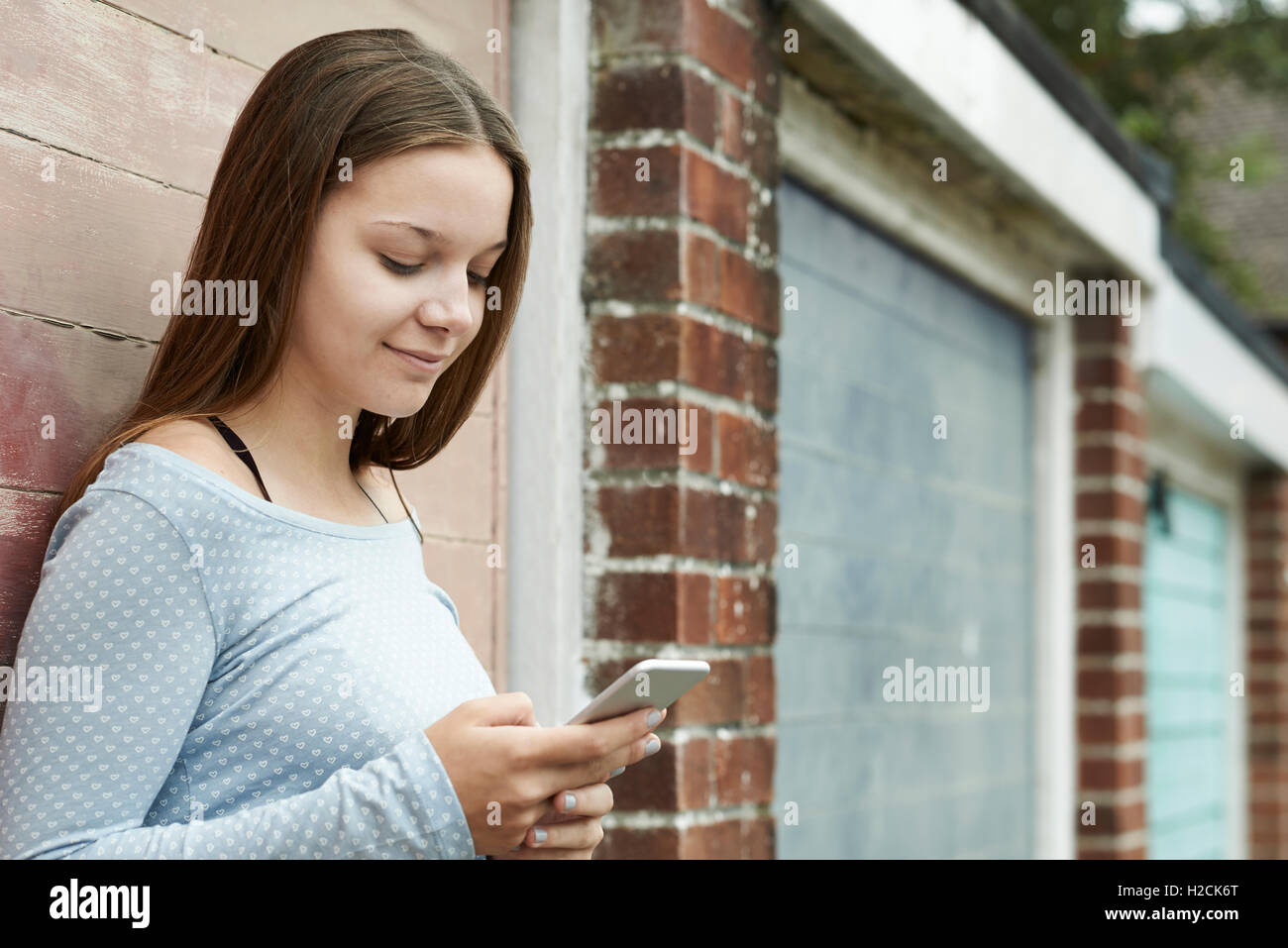 Teenager-Mädchen SMS auf Handy im städtischen Umfeld Stockfoto