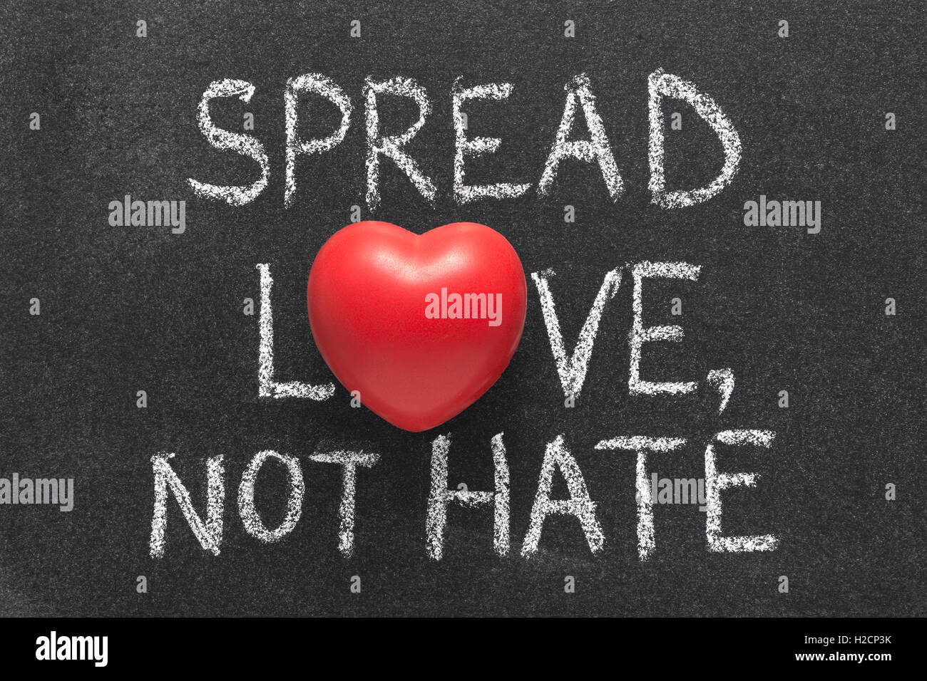 Liebe zu verbreiten, nicht hasse Ausdruck handschriftlich auf Tafel mit Herzsymbol statt O Stockfoto