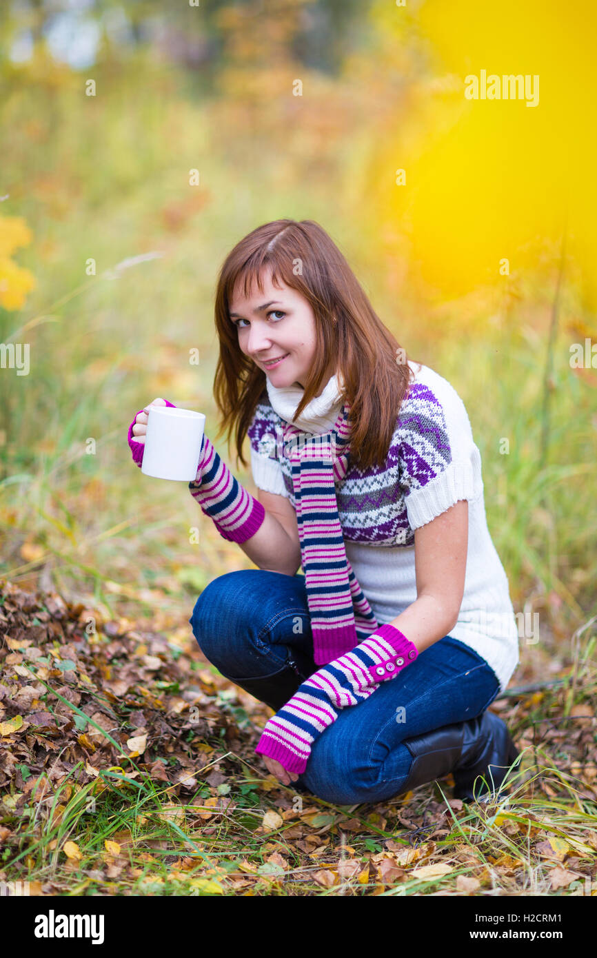 Hübsche Frau mit Teetasse in einem herbstlichen park Stockfoto