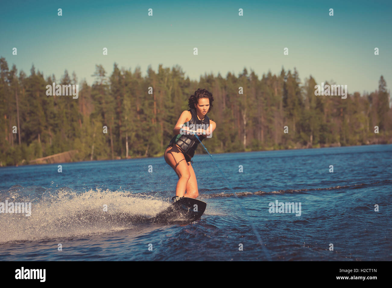 Junge hübsche Frau Studie Wakeboard fahren, an einem See Stockfoto