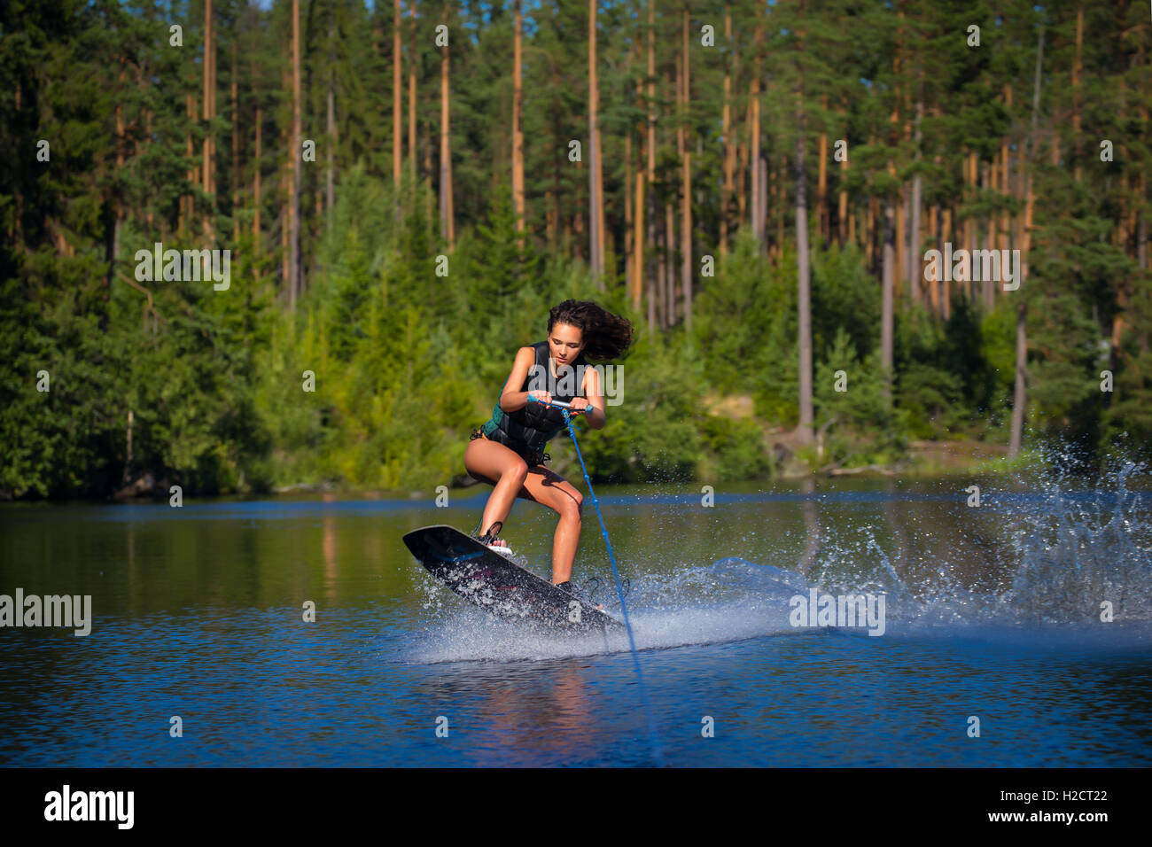 Junge hübsche Frau Studie Wakeboard fahren, an einem See Stockfoto