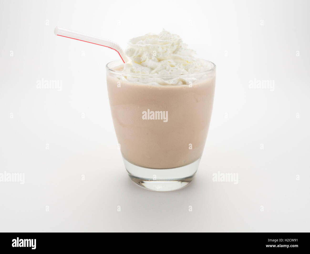 Milch-Shake mit Stroh und Sahne auf weißem Hintergrund Stockfoto