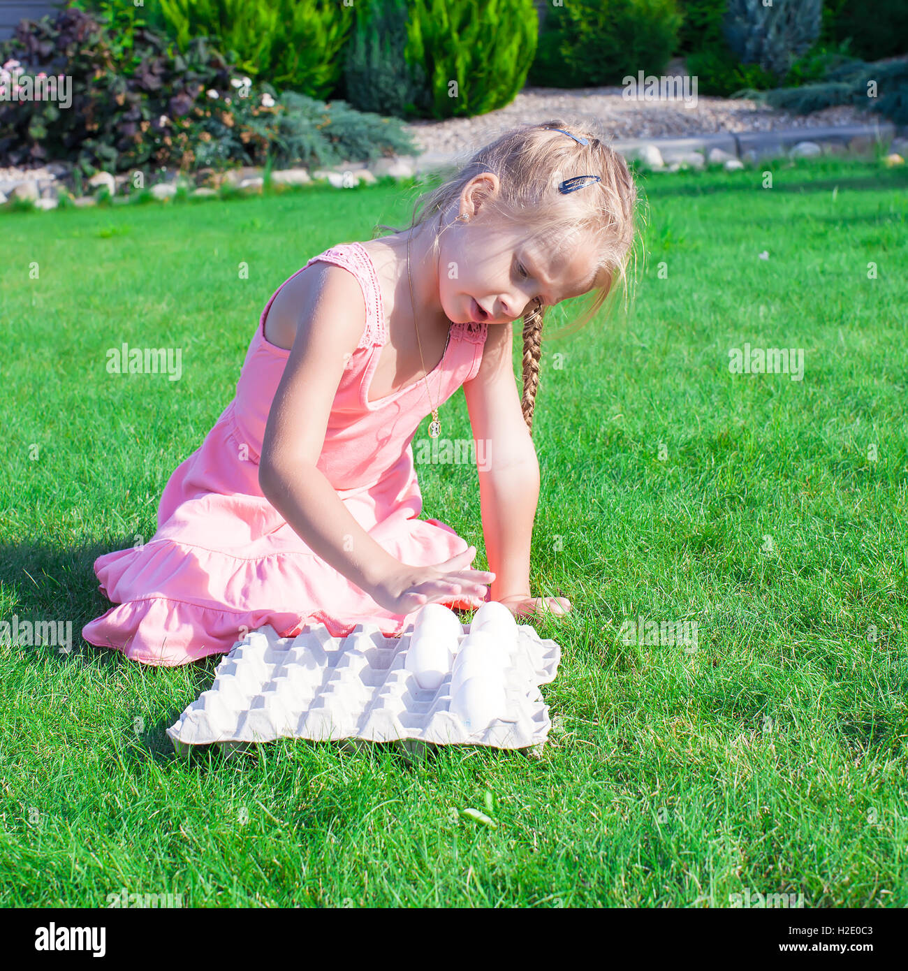 Schöne Mädchen bereitet sich auf Ostern mit einem Tablett mit weißen Eiern Stockfoto