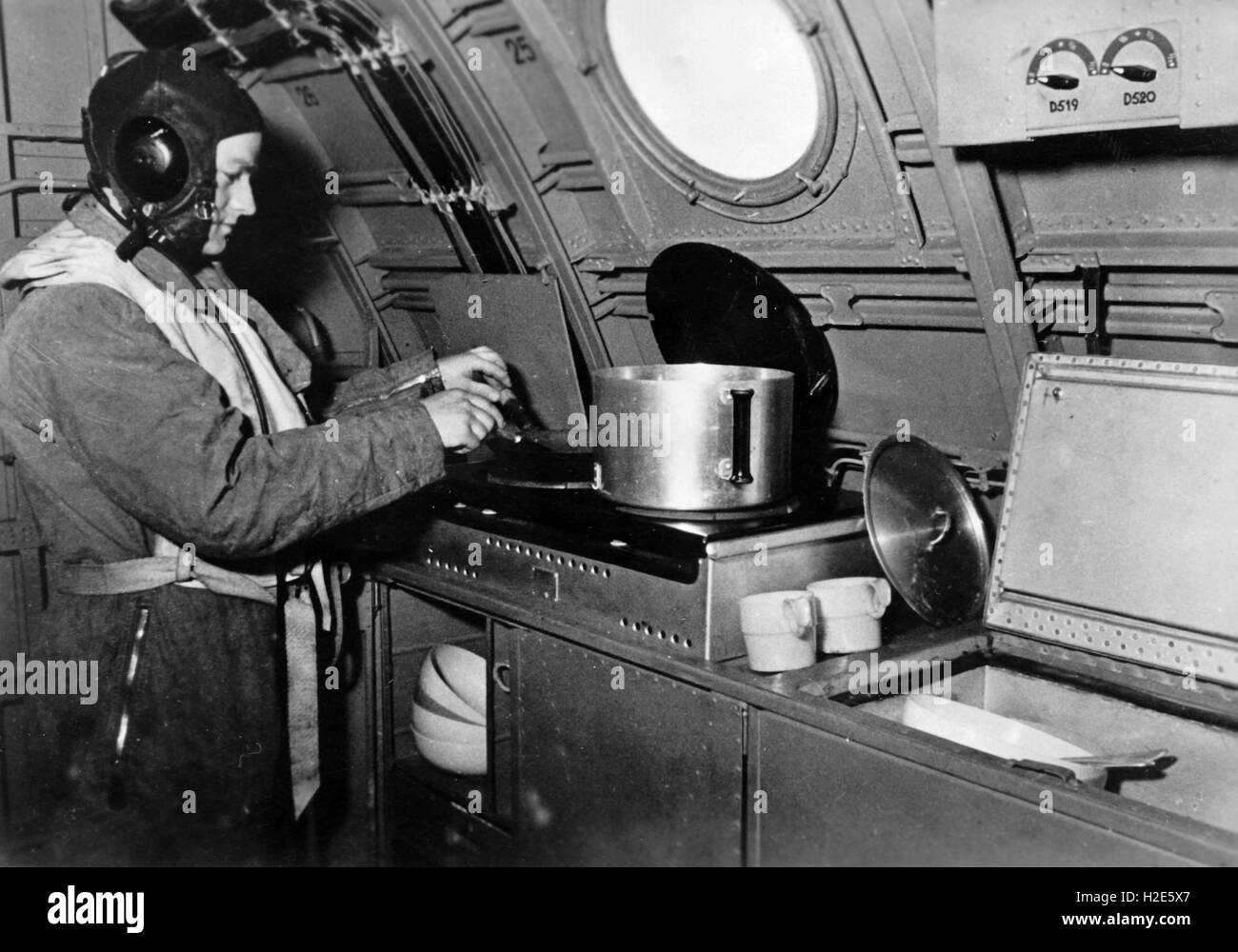 Das Bild der Nazi-Propaganda zeigt ein Besatzungsmitglied der deutschen Wehrmacht in der Küche des Flugzeugs Blohm & Voss BV 222, das eine warme Mahlzeit zubereitet. Das Foto wurde im Juli 1944 veröffentlicht. Fotoarchiv für Zeitgeschichte - KEIN KABELDIENST - | weltweite Nutzung Stockfoto