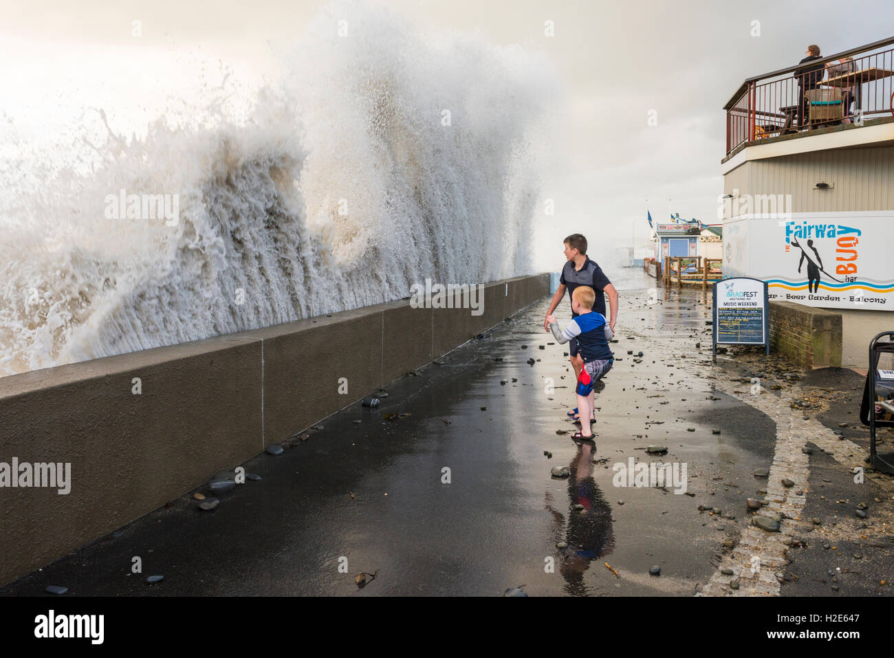 Wellen über den Deich bei Westward Ho! während einer Springflut während die Menschen versuchen und das Wasser ausweichen. Stockfoto