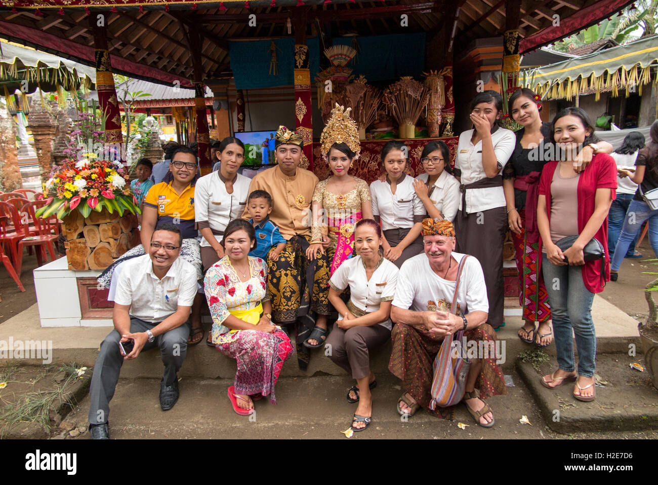 Indonesien, Bali, Payangan, Susut, Hochzeiten, Gruppe mit paar im Dorf Haus zusammengesetzten und westliche Touristen in sarong Stockfoto