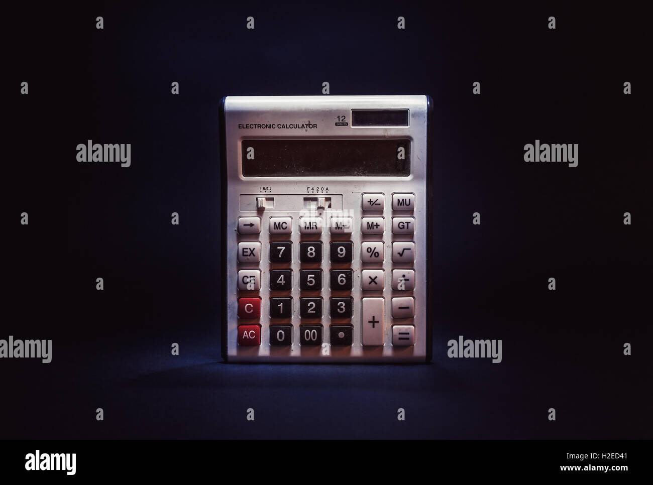 Details eines weißen verstaubt und alt elektronischen Taschenrechners, auf schwarzem Hintergrund. Stockfoto