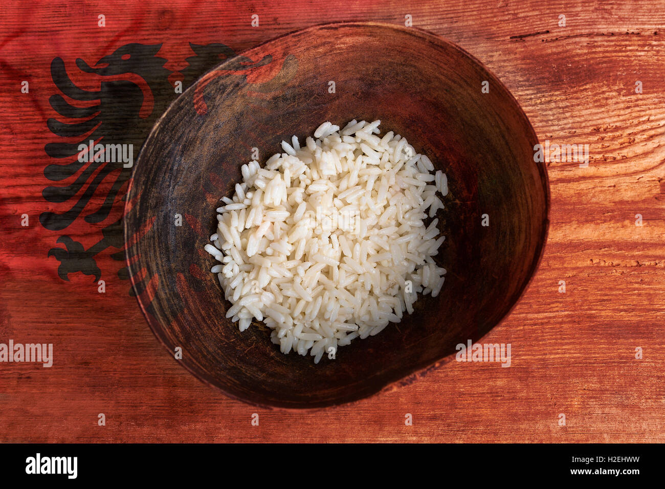 Armut-Konzept, Schüssel Reis mit albanischen Flagge auf hölzernen Hintergrund Stockfoto