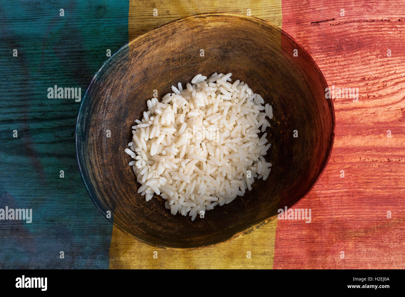 Armut-Konzept, Schüssel Reis mit rumänische Flagge auf hölzernen Hintergrund Stockfoto