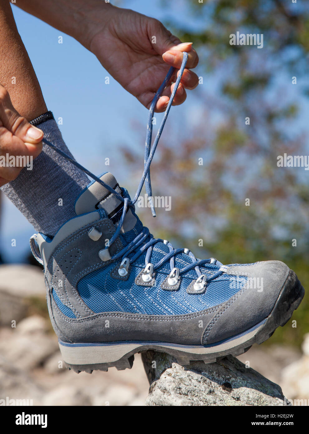 Wanderer, die binden Boot Laces, hoch in den Bergen Stockfoto