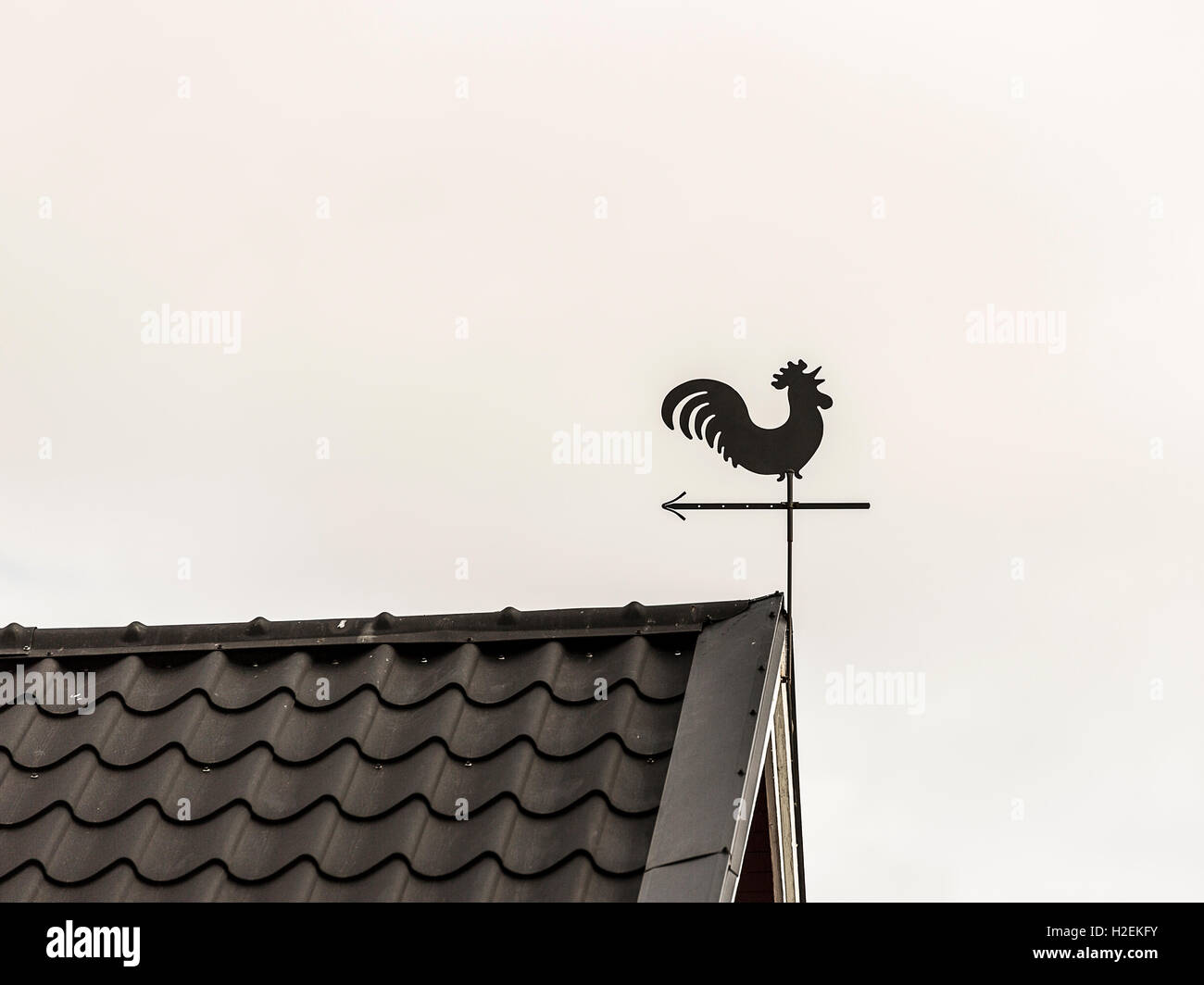 Wetterfahne Hahn am Dachfirst. Stockfoto