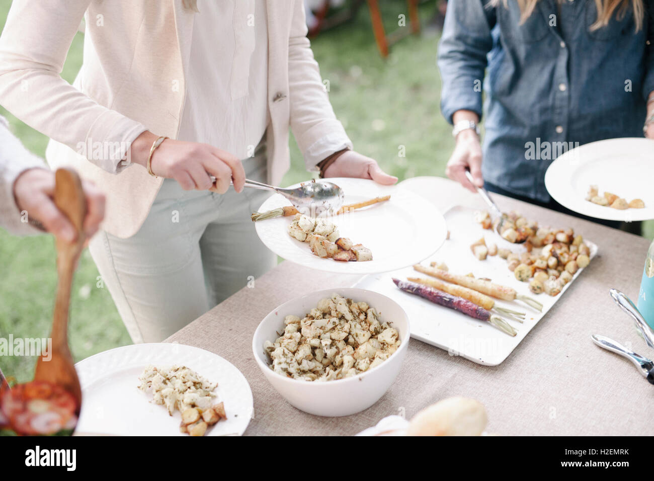 Teller und Schüsseln mit Essen auf dem Tisch auf einer Gartenparty. Stockfoto