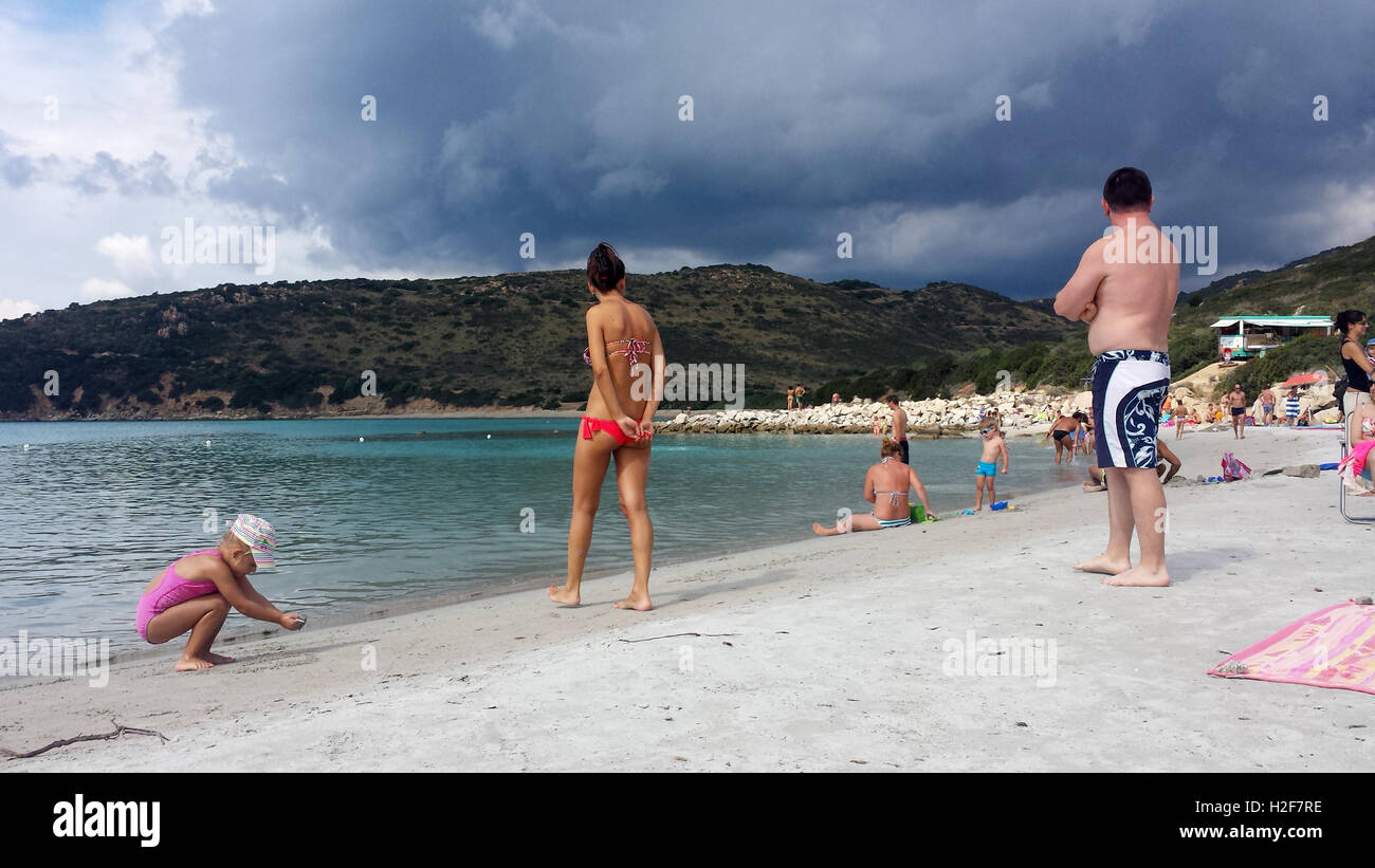 Punta Molentis Strand, Villasimius - 26 Septmber 2016: Uninidentify Menschen am Strand während eine schwarze Wolke in den Himmel kommt Stockfoto