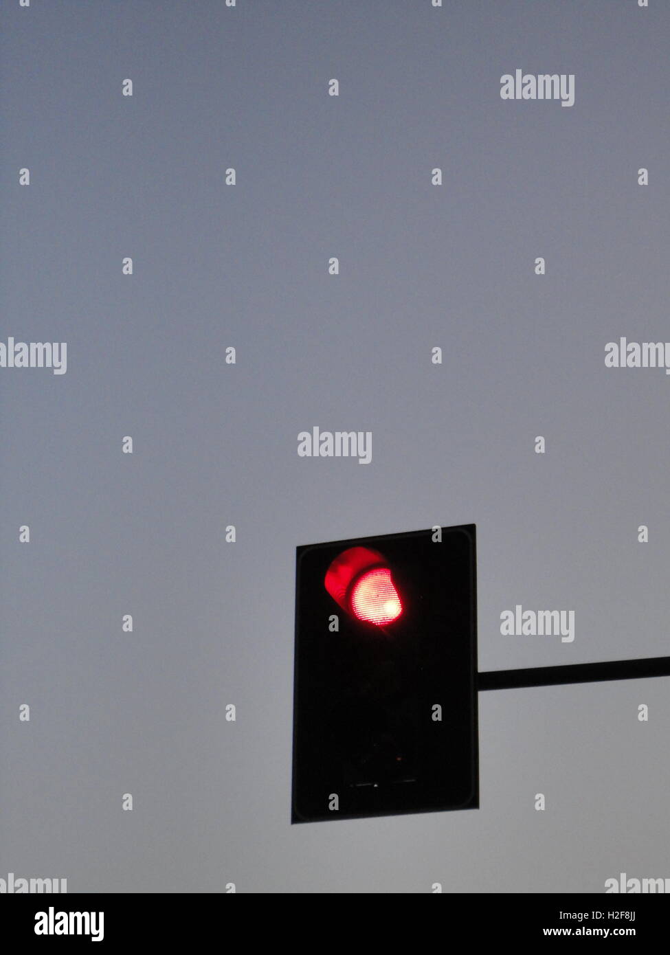 Rote Ampel in der Dämmerung gegen ein strahlend blauer Himmel, Mailand Stockfoto