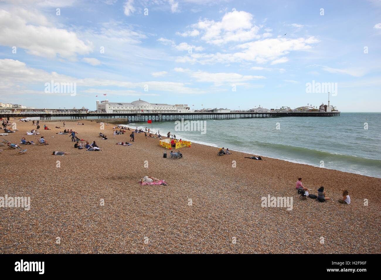 Die berühmten Brighton Pier aus der Ferne mit dem Strand und Touristen an einem schönen sonnigen Tag, England Stockfoto