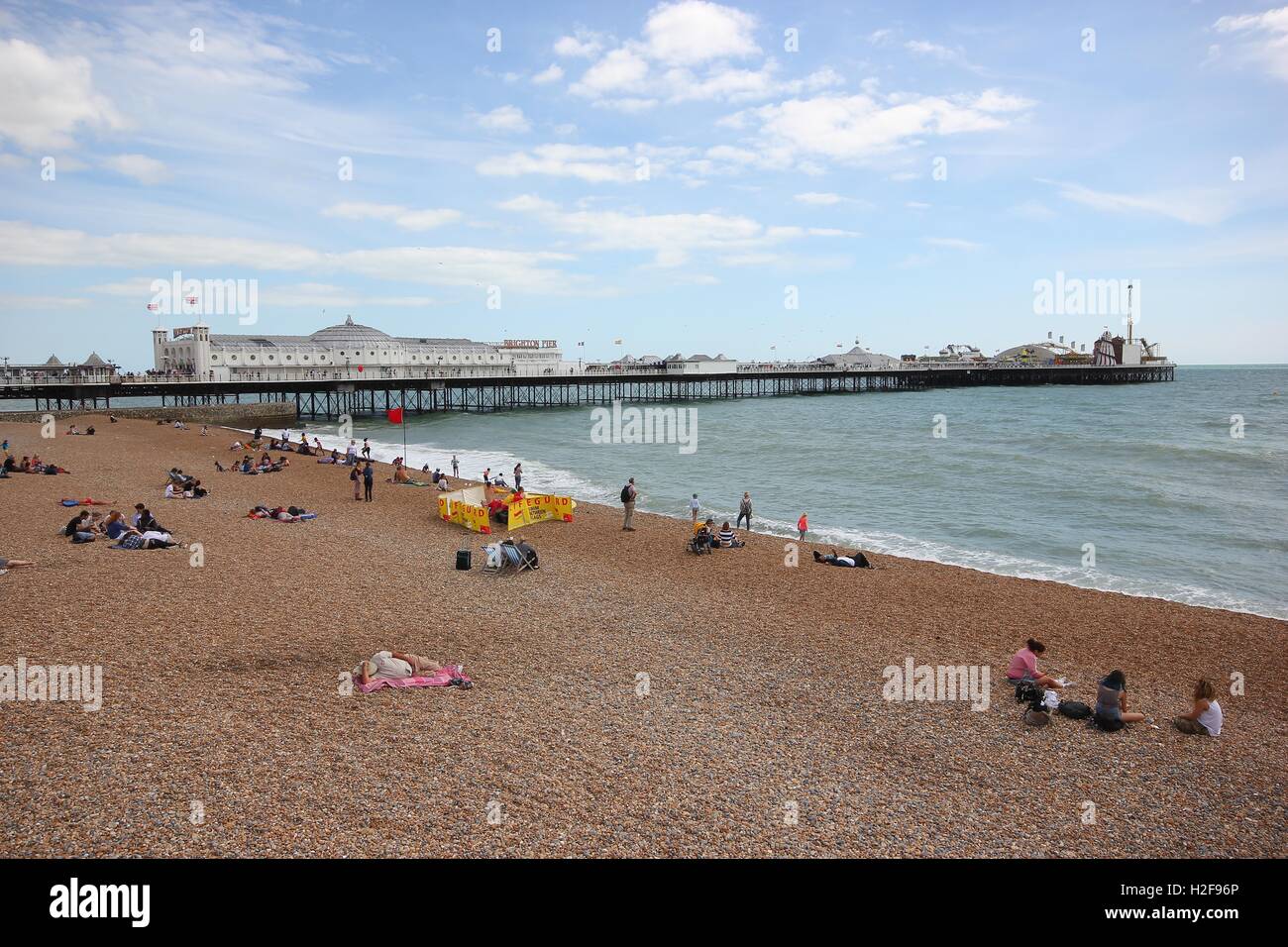 Die berühmten Brighton Pier aus der Ferne mit dem Strand und Touristen an einem schönen sonnigen Tag, England Stockfoto