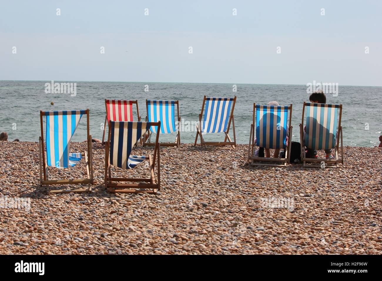 Bunt gestreiften Strand Liegestühle auf den gepflasterten Strand, Brighton, England Stockfoto