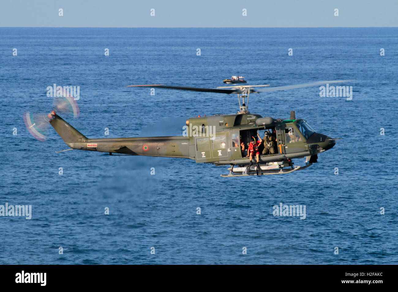 Hubschrauber schwebt. Taucher Vorbereitung auf Sprung von einer italienischen Luftwaffe oder Aeronautica Militare Italiana Agusta-Bell AB212 während einer Rettungssimulation Stockfoto