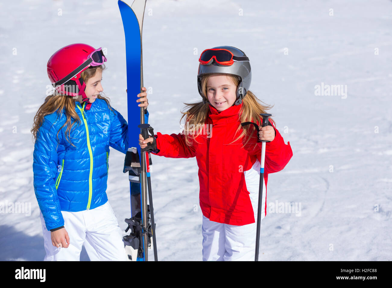 Kind Mädchen Schwester im Winterschnee mit Skiausrüstung Stockfoto