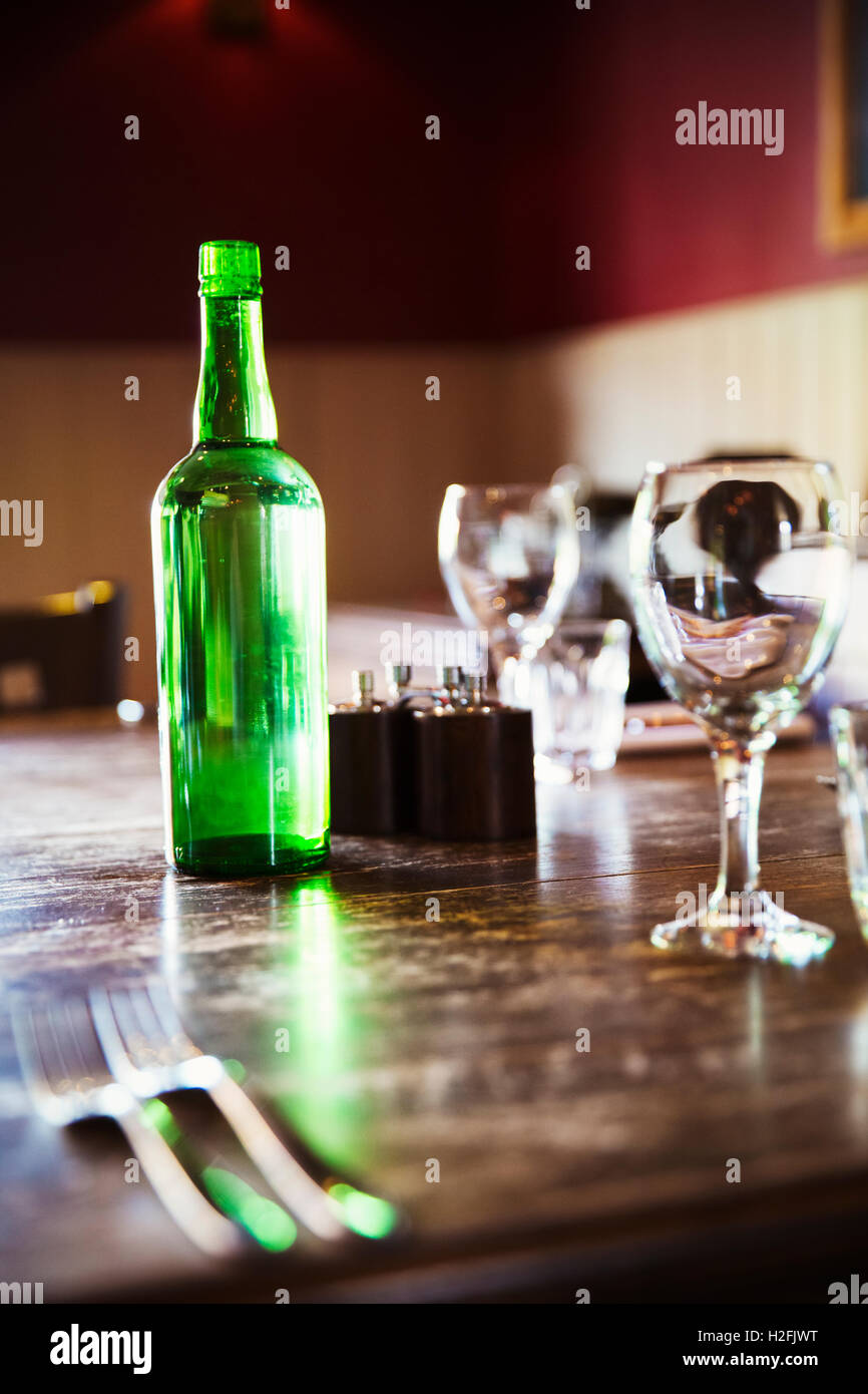 Dorf-Gasthaus. Eine Tabelle mit Besteck und Gläser und grüne Flasche Wasser gelegt. Stockfoto
