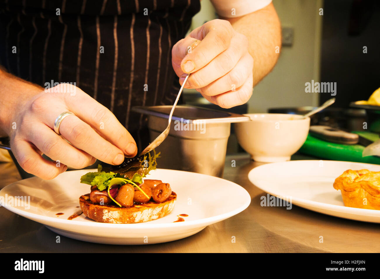 Gastwirtschaft Dorfrestaurant. Ein Koch, Galvanik, ein Gericht aus Fleisch und Gemüse. Stockfoto